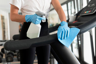 Clean gym equipment with a rag